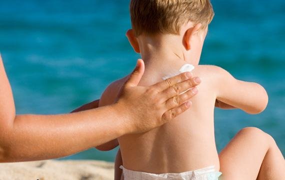 Sun Protection, Mother Applying Suntan Lotion On Her Little Baby.