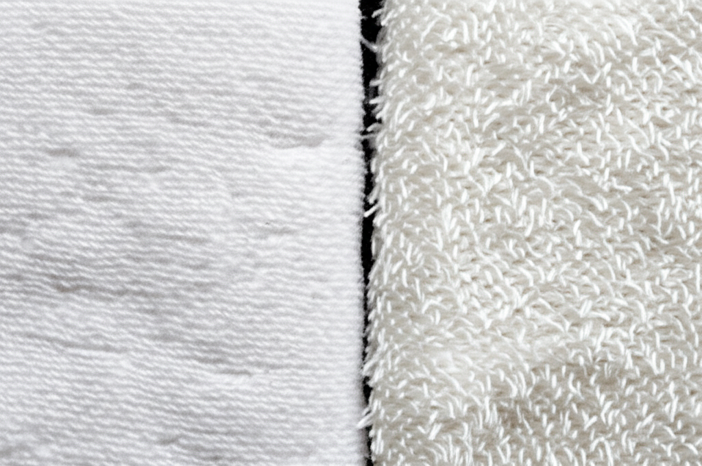 Ảnh chụp cận cảnh hai loại khăn nén khác nhau. Một chiếc làm từ cotton thật với sợi vải mềm mại, mịn màng. Chiếc còn lại làm từ sợi tổng hợp kém chất lượng với sợi vải thô ráp, xơ xác. Chụp dưới ánh sáng tốt để thấy rõ kết cấu sợi vải.